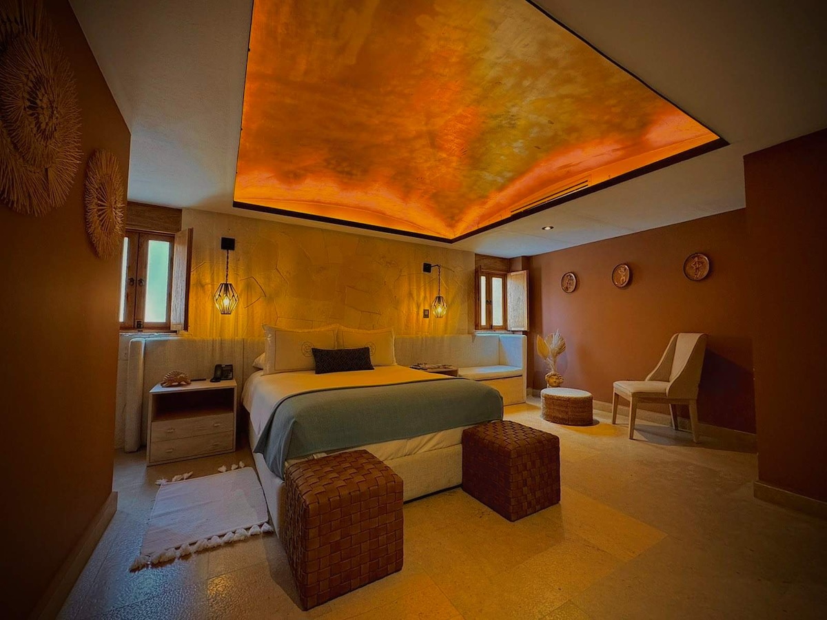 Barro boutique queen suite with warm lighting and stone finishes