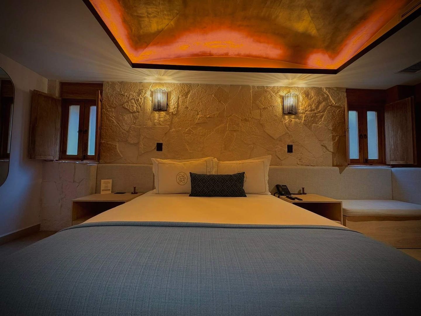 Cobre luxury queen room with warm ambient lighting and stone finishes
