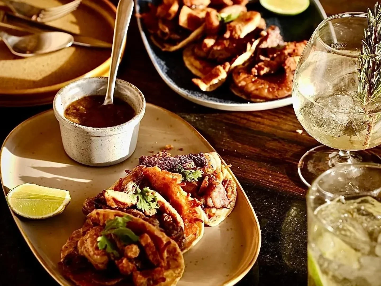 Tacos with cilantro and a side of salsa, with cocktails