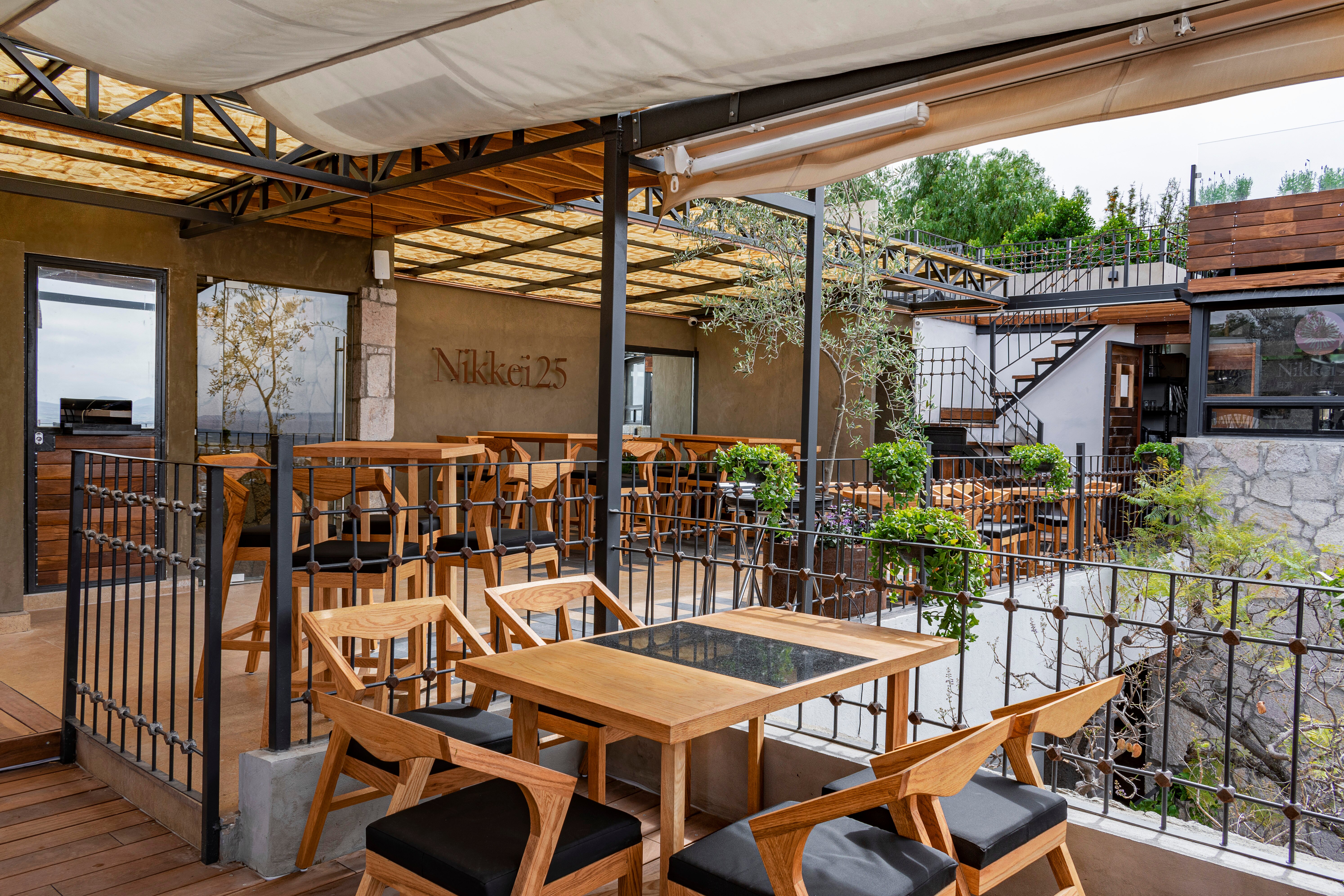 Nikkei 25 rooftop restaurant terrace with wooden tables and city views