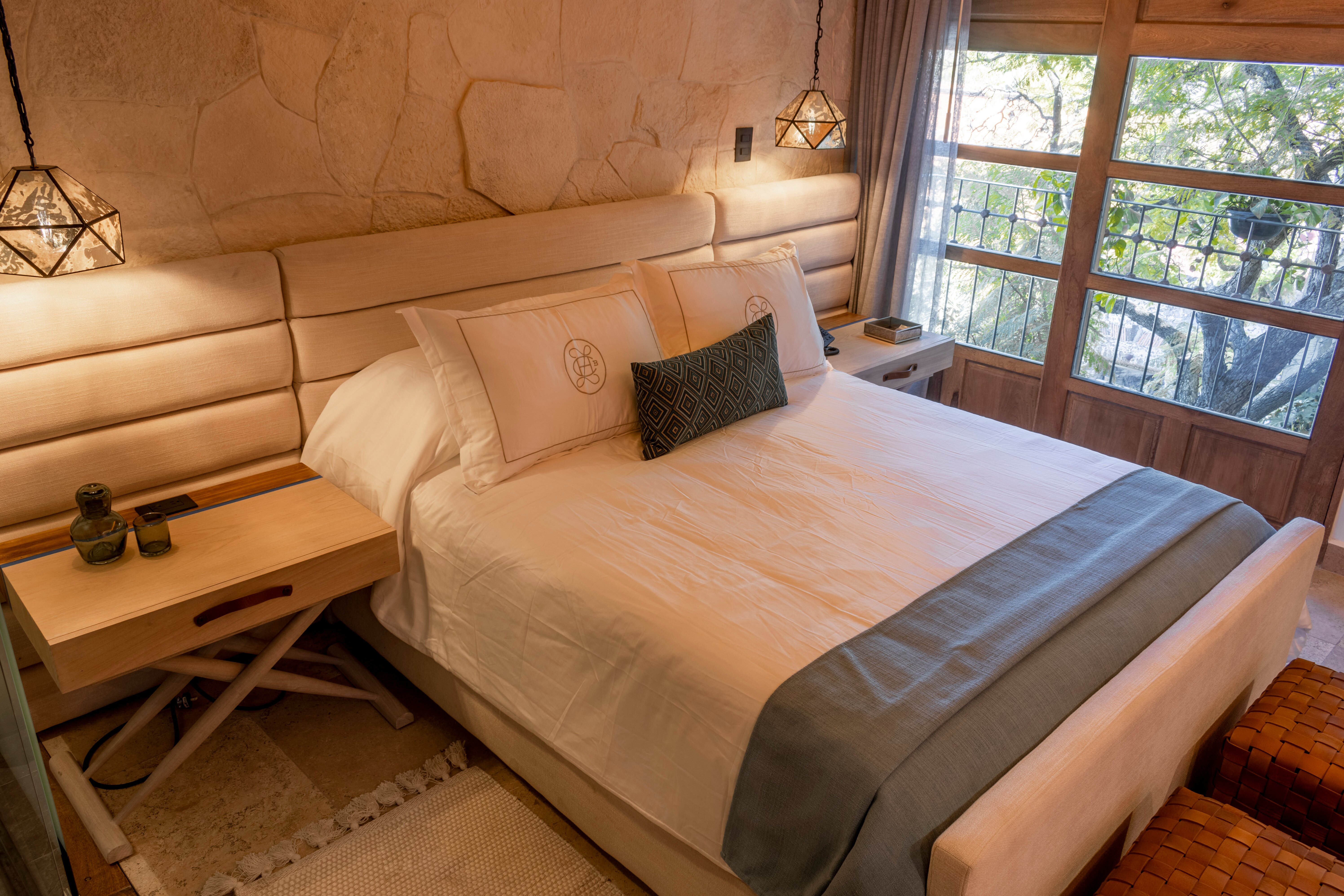 Queen bed beside a city-facing window