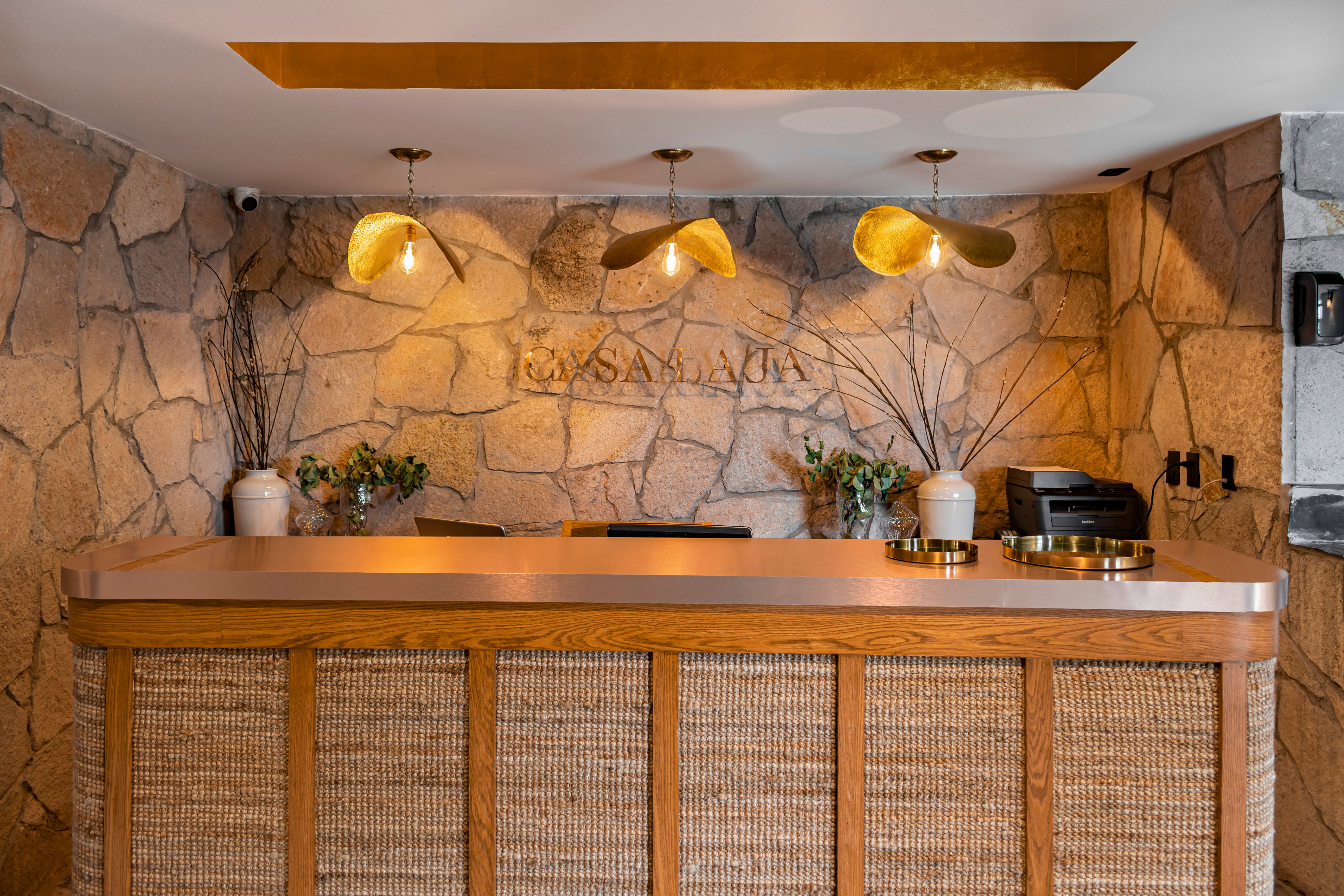 Reception desk in stone and woven wood with brass pendants