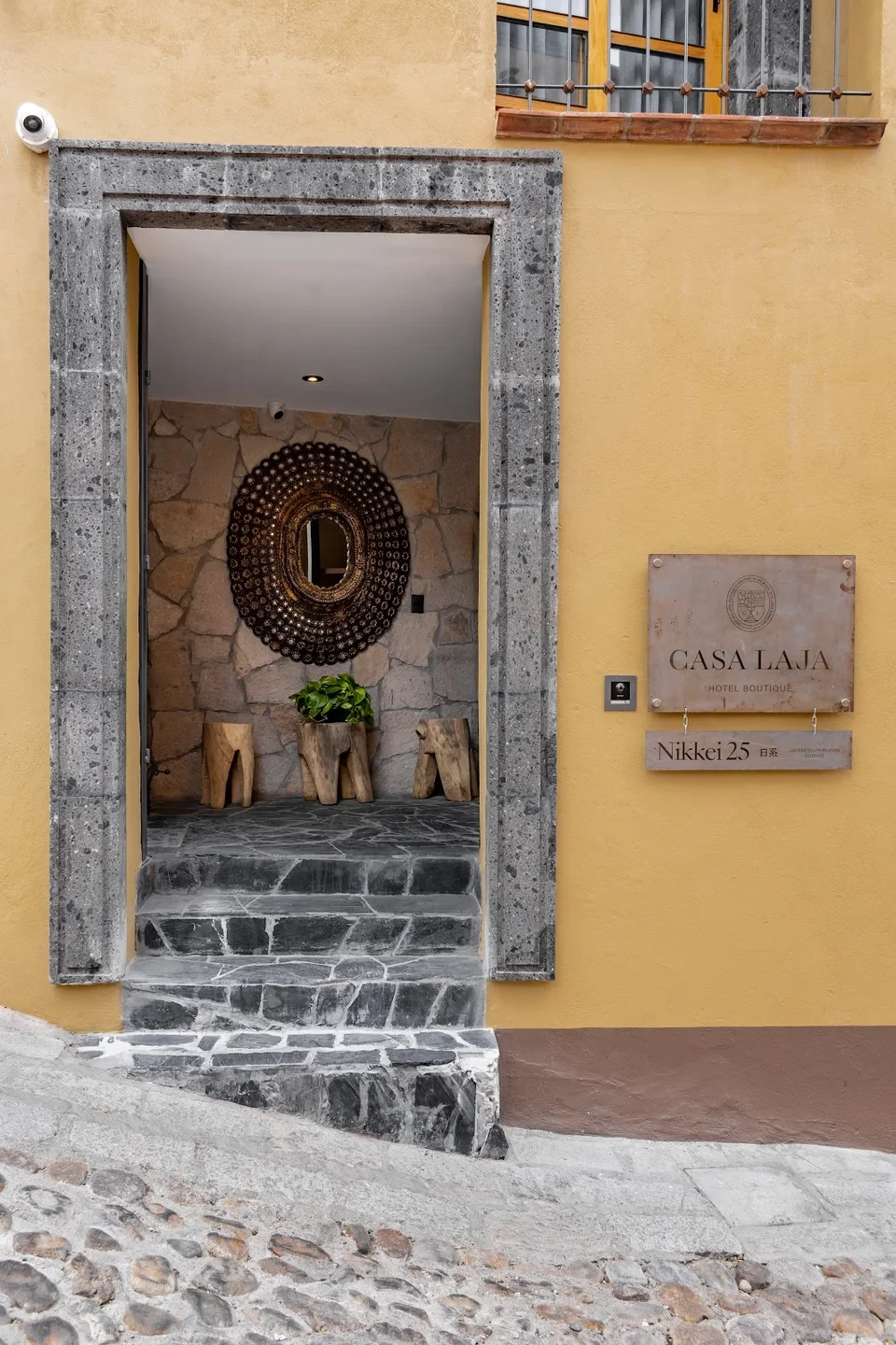 Casa Laja street entrance with a carved stone doorway and brass nameplate