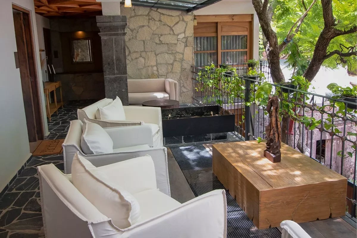Lounge seating beneath a tree on the stone-floored terrace