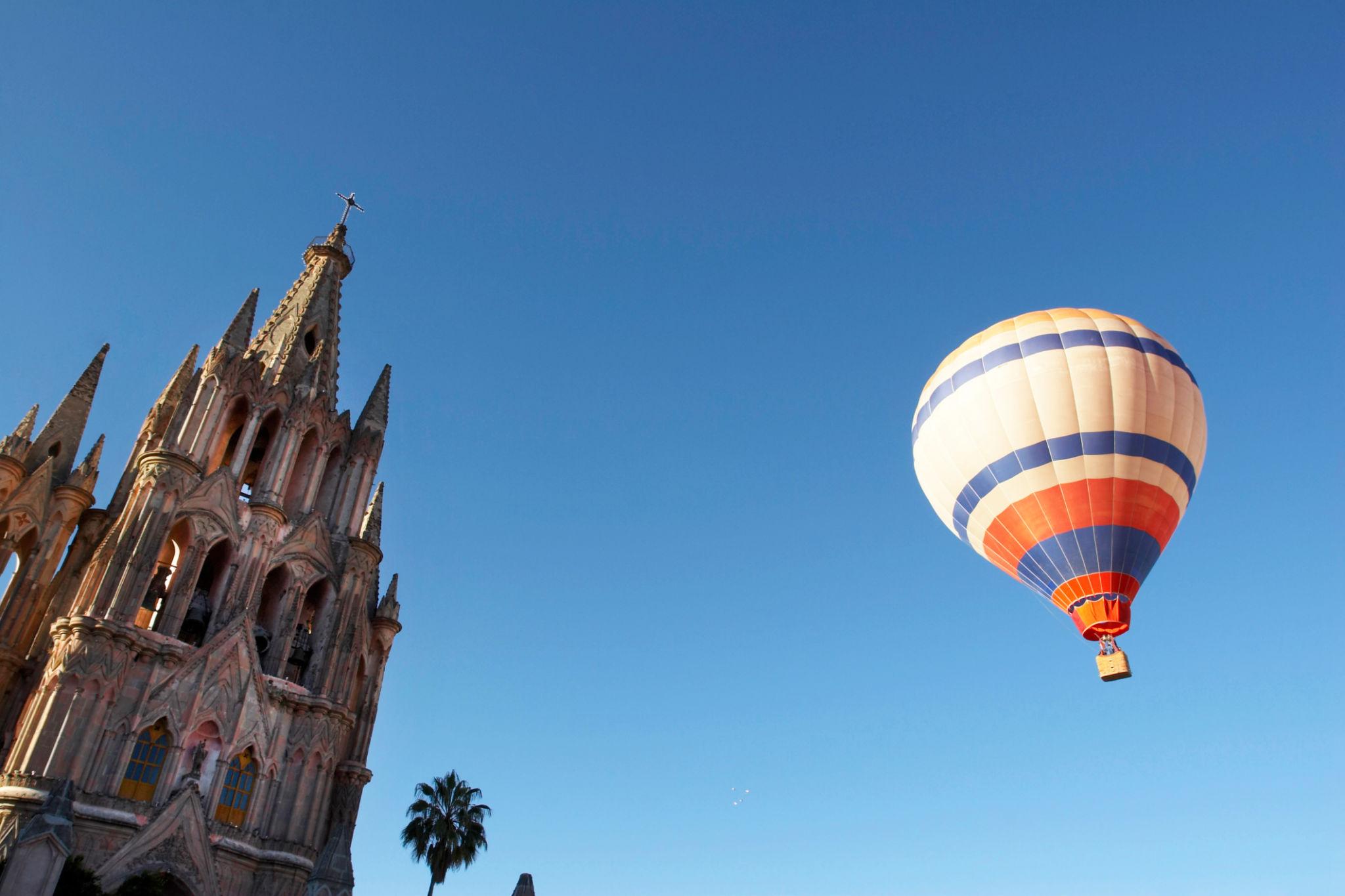 Hot air balloons drifting over San Miguel de Allende at sunrise