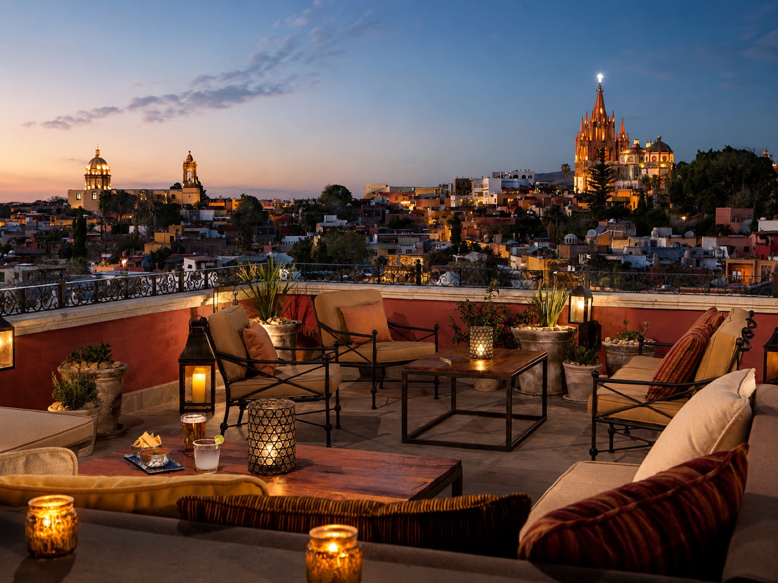 Candlelit rooftop lounge at Casa Nostra at dusk overlooking the illuminated Parroquia and the lights of San Miguel