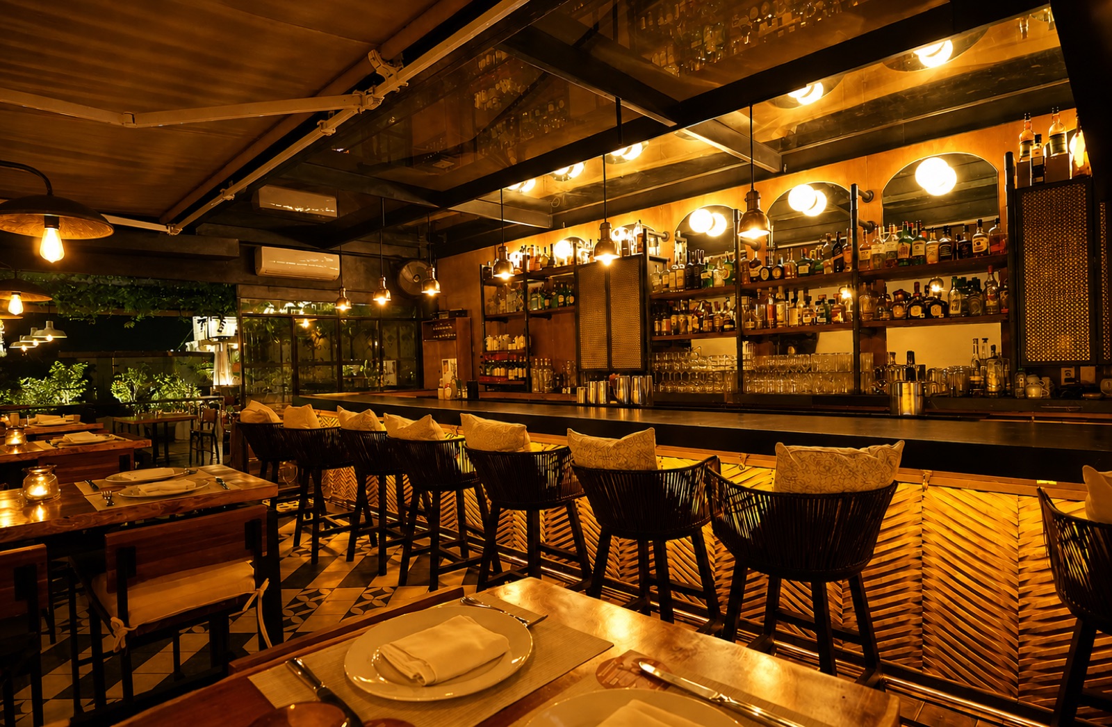 The warm, candlelit bar at La Unica with a bottle-lined back bar and woven leather stools
