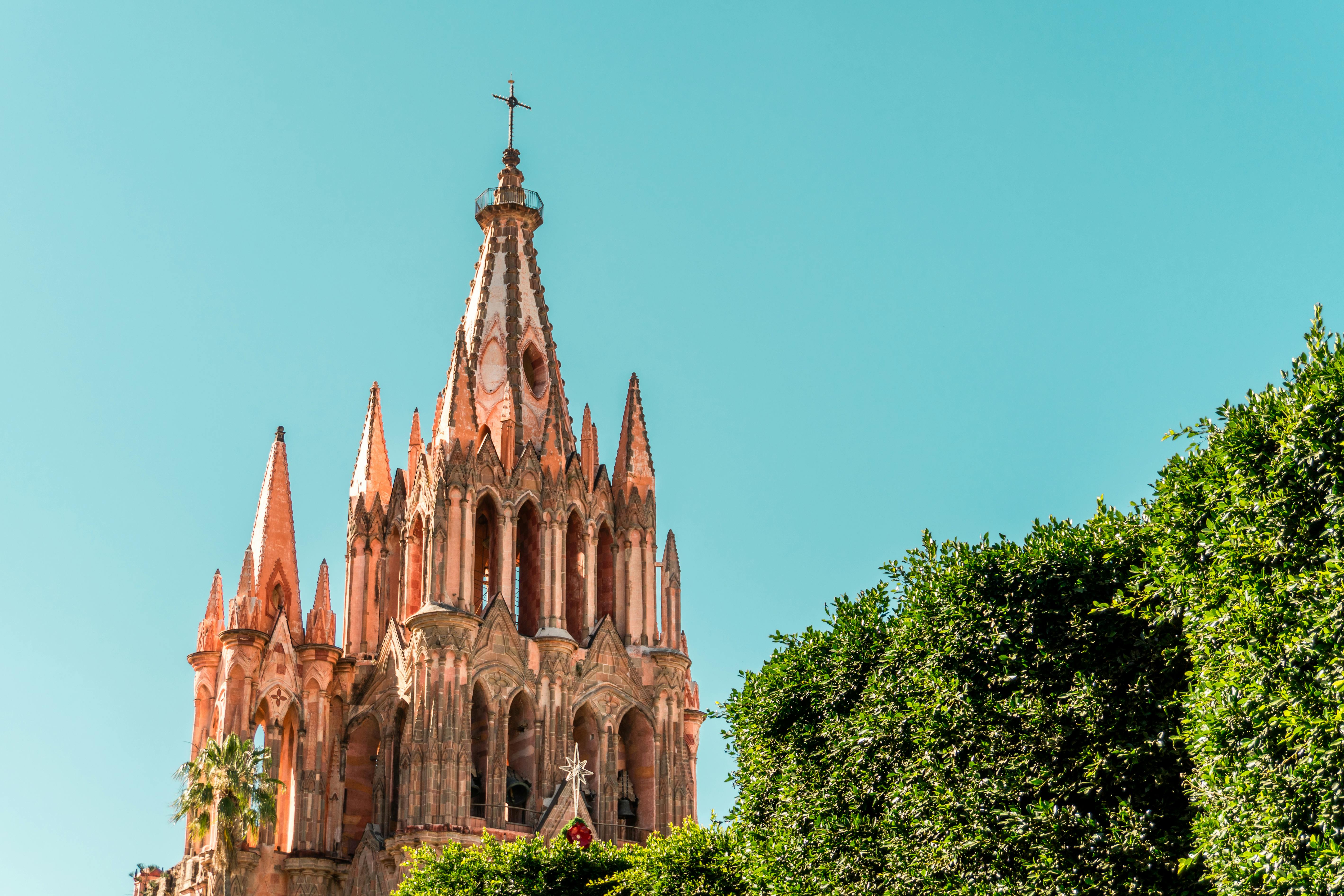 The neo-Gothic spires of the Parroquia de San Miguel Arcángel against a clear sky